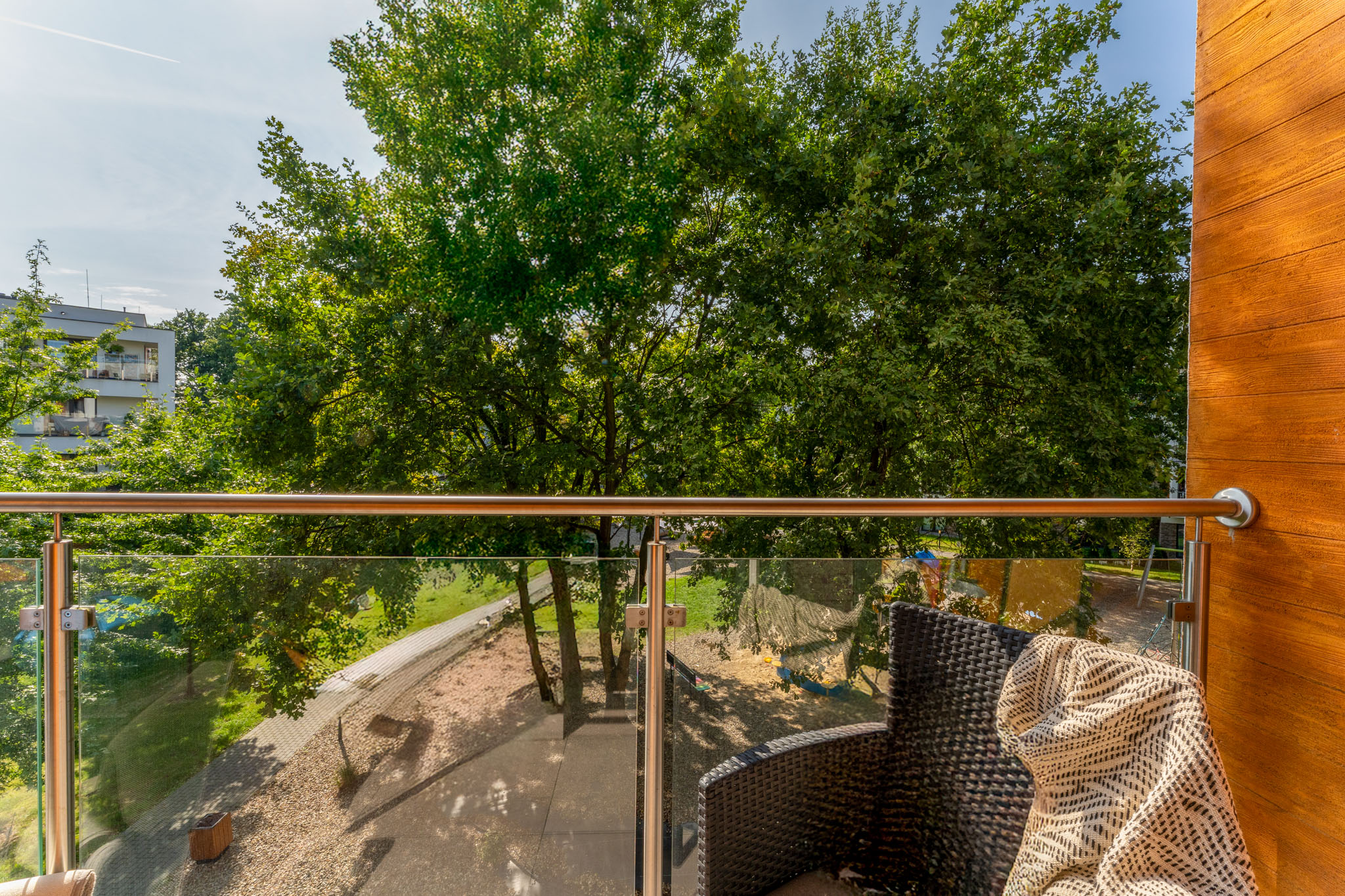 widok na balkon i zieleń za oknem plac zabaw