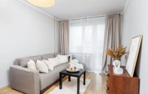 Jasny salon z wyjściem na duży balkon w 3-pokojowym mieszkaniu na sprzedaż przy ul. Półkole w Krakowie