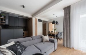 salon nowoczesne 4 pokojowe mieszkanie na sprzedaż w stylu skandynawskim drewno, biel, przytulne wnętrze, tapety widok na salon i jadalnie